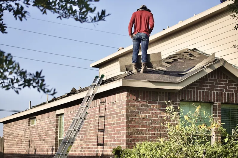 Professional roofer working on a residential roof in Lees